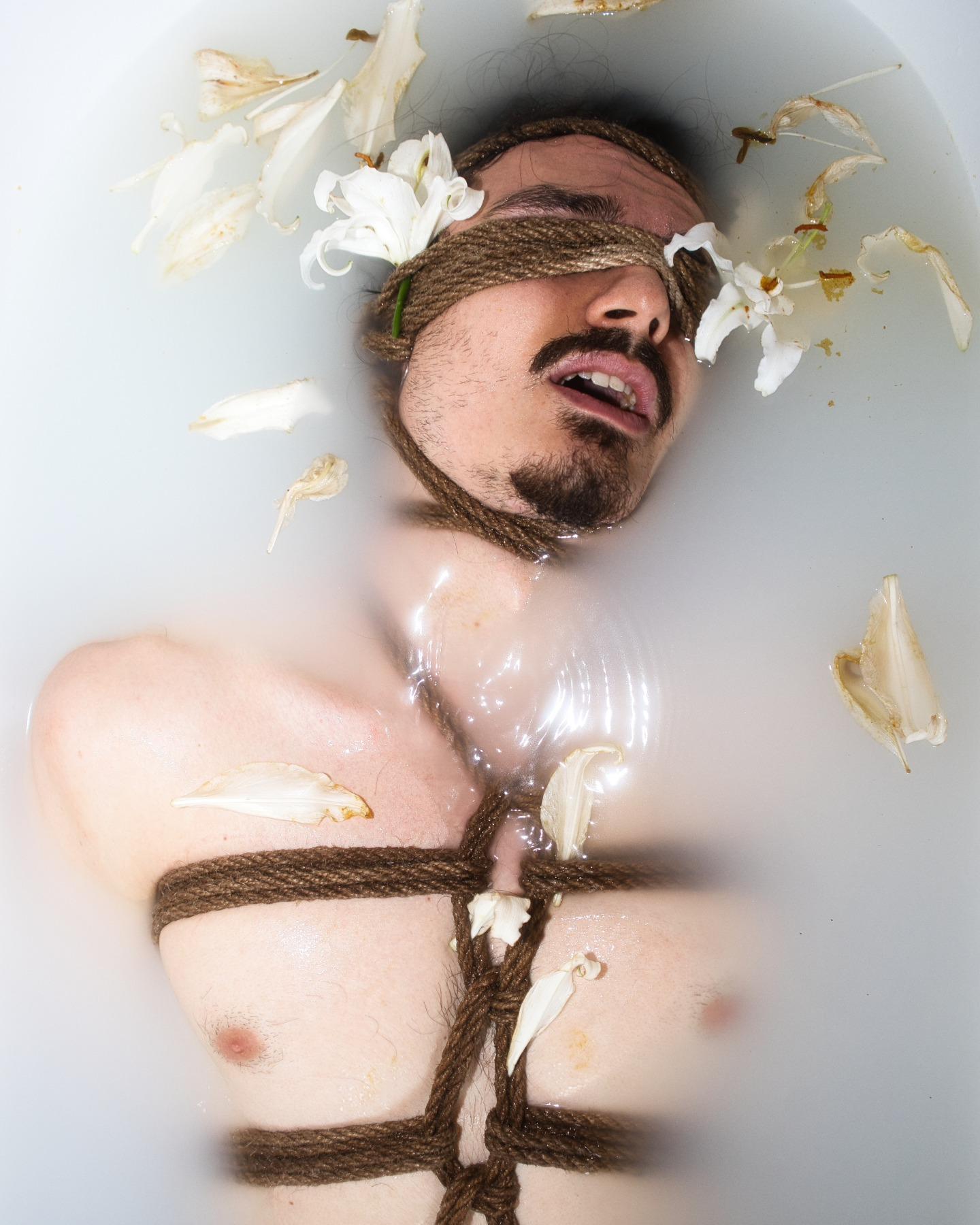 Rope-bound portrait among lilies in a milk bath